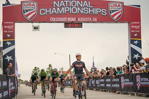 Evan Bausbacher celebrating at the finish after winning the 2019 USA Cycling Collegiate Road Race National Championship in Augusta, Georgia